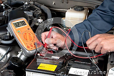 Auto mechanic checking car battery voltage Stock Photo