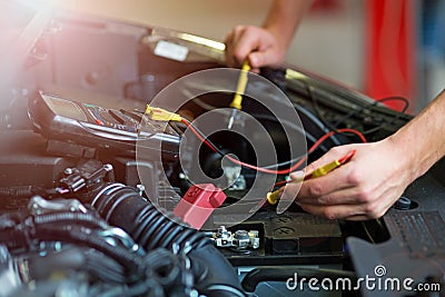 Auto mechanic checking car battery voltage Stock Photo