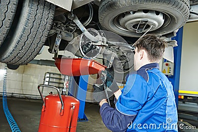 Auto mechanic disassembling axle Stock Photo