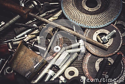 Auto mechanic metal parts and tools on a table. Close up view of finishing equipment, drills, bits, screws, bolts. Stock Photo