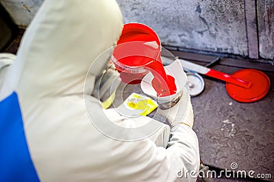 Auto mechanic mixing and pouring red paint Stock Photo