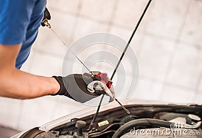 Auto mechanic repairer checking level of oil in car engine Stock Photo