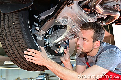 Auto mechanic repairs vehicle in a workshop Stock Photo