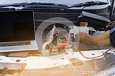 Auto mechanic uses a multimeter voltmeter. Stock Photo