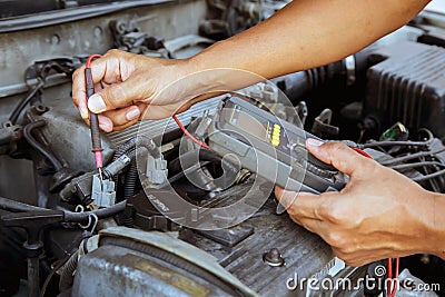 Auto mechanic using measuring equipment for checking car electrical. Stock Photo