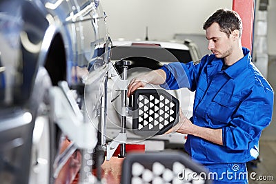 Auto mechanic at wheel alignment work with sensor Stock Photo