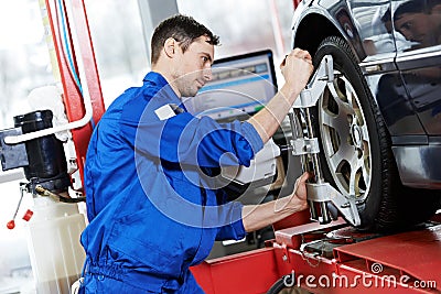 Auto mechanic at wheel alignment work with spanner Stock Photo