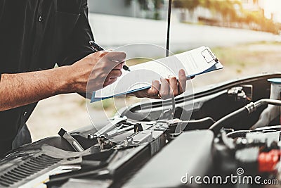 Auto mechanic working in garage Technician holding clipboard and check mechanic Maintenance car check Stock Photo