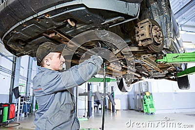 Auto repair service. Mechanic works with car suspension Stock Photo