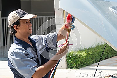 Auto repairman checks the engine and cooling system before traveling on a long holiday. Concept of Car care and maintenance from Stock Photo