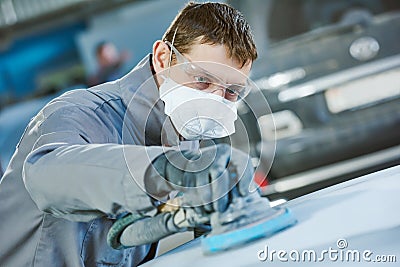 Auto repairman grinding autobody bonnet Stock Photo