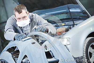 Auto repairman grinding autobody bonnet Stock Photo