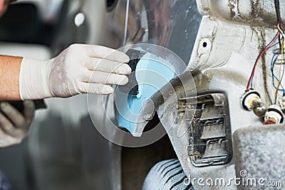 Auto repairman plastering autobody bonnet Stock Photo