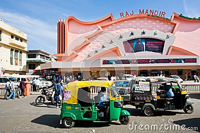 Auto rickshaw transport drive past movie theater Editorial Stock Photo