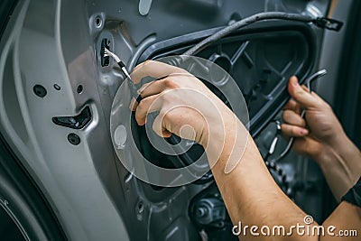 Auto service worker disassembles car door for repair, restoration, tuning car sound or installing noise insulation or Stock Photo