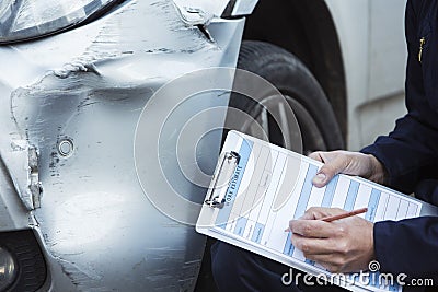 Auto Workshop Mechanic Inspecting Damage To Car And Filling In R Stock Photo