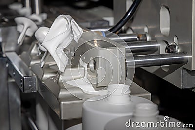 Automated production line for casting white plastic bottles. White plastic bottles on a production line. Molding of Stock Photo