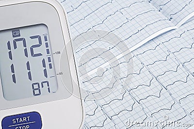 Automatic blood pressure meter on cardiogram graph background Stock Photo