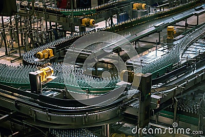Automatic conveyor line or belt with glass bottles at brewery production. Industrial beer bottling equipment machinery Stock Photo