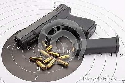 Automatic handgun pistol and bullets on bull eye target background Stock Photo