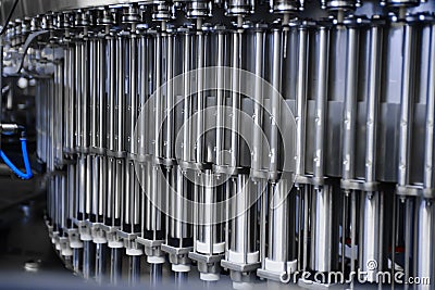 Automatic line for filling beer and water into plastic bottles. Industrial production of beverages. Capping machine. Stock Photo