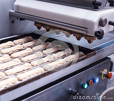 Automatic line for the production of eclairs. Eclair Cake Dough Baking, preparation Stock Photo