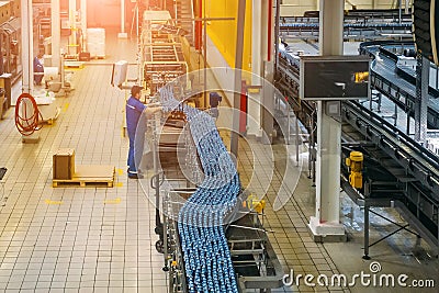 Automatic modern production line at brewery. Conveyor line and vats for fermentation and pasteurization Editorial Stock Photo