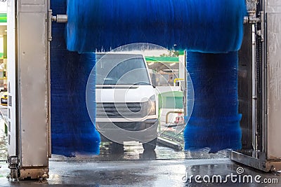 Automatic wash blue brush rotate in action, white mini vancar comes out ready clean Stock Photo