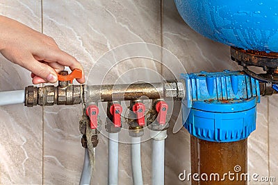 Automatic water supply system, hands turn off the main valve. Stock Photo