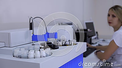 Automatische biochemische analysatormachine in dokterslaboratorium en de vrouwenwerken aangaande computer stock footage Automatische biochemische analysatormachine in dokterslaboratorium en de vrouwenwerken aangaande computer stock footage