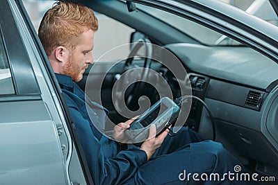 Automechanic using car diagnostic tool Stock Photo