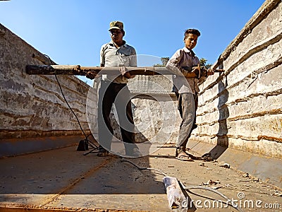 automobile workers holded iron logs into the truck at workshop in india dec 2019 Editorial Stock Photo