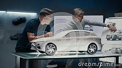 Automotive engineers discuss car design making corrections in sculpture of a car Stock Photo