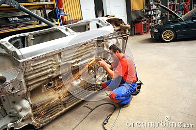 Automotive worker grinding the car Editorial Stock Photo