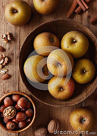 Autumn apples with nuts and cinnamon sticks on table Stock Photo