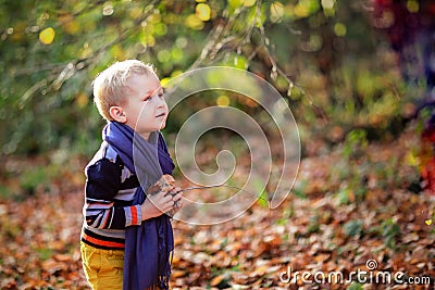 Autumn baby boy and his mother throwing yellow leaves Stock Photo