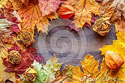 Autumn background of yellow and red maple leaves and dried roses. Copy space Stock Photo