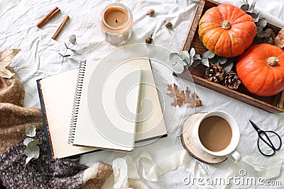 Autumn breakfast in bed composition. Blank notepad, book mockup. Coffee, candle,eucalyptus leaves and pumpkins on wooden Stock Photo