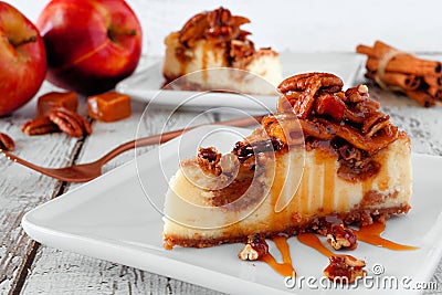 Autumn caramel apple pecan cheesecake slices, side view table scene against white wood Stock Photo