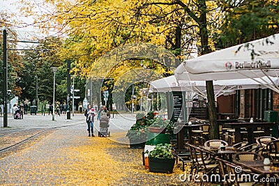 Berlin, December 12, 2017: The autumn city scene. Street in Berlin. The yellow foliage lies on the sidewalk. The family Editorial Stock Photo