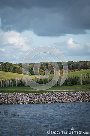 Autumn colors on trees and rolling green hills and water as layers outside Lund Sweden Stock Photo
