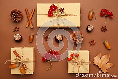 Autumn composition and gifts on brown background. Pattern made of autumn leaves, acorn, pine cones Stock Photo