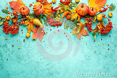 Autumn concept with pumpkins, flowers, autumn leaves and rowan berries on a turquoise background. Festive autumn decor, flat lay Stock Photo