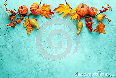 Autumn concept with pumpkins, flowers, autumn leaves and rowan berries on a turquoise background. Festive autumn decor, flat lay Stock Photo