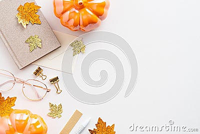 Autumn desk table with maple leaves, pumpkins, paper notebook, glasses. Cozy feminine workspace. Flat lay, top view, copy space Stock Photo