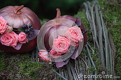 Autumn DÃ©cor with bouquet of roses and grapes in the golden pumpkin. Stylish Halloween decorations. Shiny Decorative Pumpkins. Stock Photo