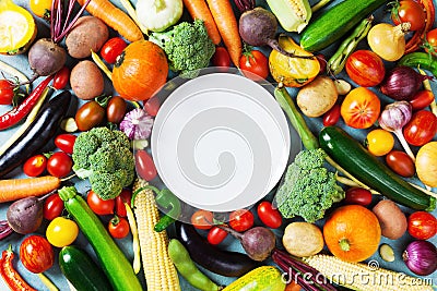 Autumn farm vegetables, root crops and white plate top view with copy space for menu or recipe. Healthy and organic food. Stock Photo