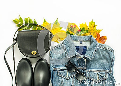 Autumn fashion, woman autumn outfit on white background. Blue denim jacket , retro sunglasses, black crossbody bag, black rain boo Stock Photo