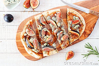 Autumn flat bread pizza with figs, caramelized onions, blue cheese and rosemary, top view table scene on white wood Stock Photo