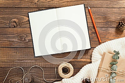 Autumn flatlay composition. Top view on book with empty pages, red pen, rope, gift box on wooden background. Autumn hygge style Stock Photo